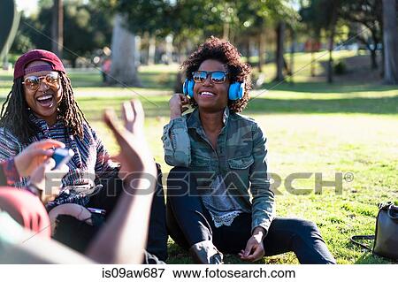 Group of female friends relaxing in park, laughing View Large Photo Image Stock Photo - Group of female friends relaxing in park, laughing. Fotosearch
