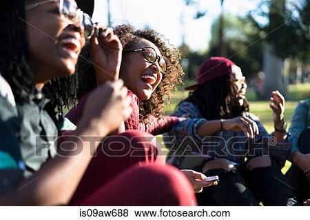 Group of female friends relaxing in park, laughing View Large Photo Image Stock Photo - Group of female friends relaxing in park, laughing. Fotosearch