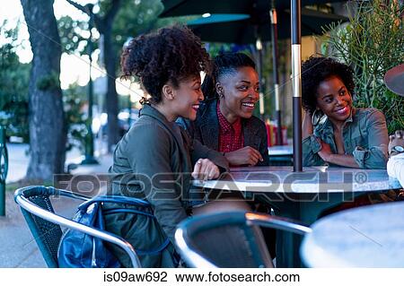 Group of female friends sitting at table, outside cafe View Large Photo Image Stock Image - Group of female friends sitting at table, outside cafe. Fotosearch