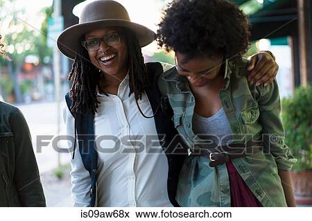 Group of female friends walking along street View Large Photo Image Stock Photo - Group of female friends walking along street. Fotosearch