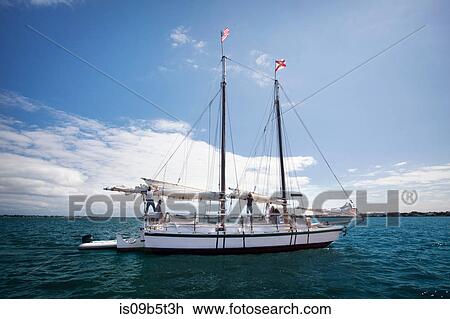 Stock Image - Group of friends on sailing boat on water. Fotosearch