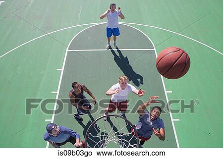 Group of male friends playing basketball on outdoor court, elevated view View Large Photo Image Picture - Group of male friends playing basketball on outdoor court, elevated view. Fotosearch