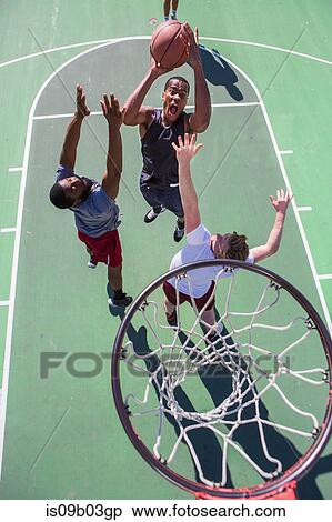 Group of male friends playing basketball on outdoor court, elevated view View Large Photo Image Stock Photography - Group of male friends playing basketball on outdoor court, elevated view. Fotosearch