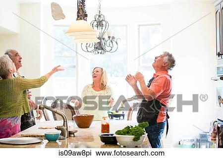 Stock Image - Group of seniors having fun in kitchen. Fotosearch