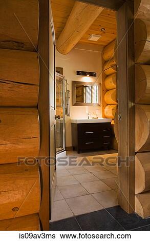 Guest bathroom with glass shower stall and wooden vanity inside a Scandinavian cottage style log home View Large Photo Image Stock Photograph - Guest bathroom with glass shower stall and wooden vanity inside a Scandinavian cottage style log home. Fotosearch