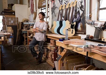 Guitar maker in workshop looking away smiling View Large Photo Image Stock Photography - Guitar maker in workshop looking away smiling. Fotosearch