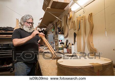 Guitar maker in workshop manufacturing guitar View Large Photo Image Picture - Guitar maker in workshop manufacturing guitar. Fotosearch