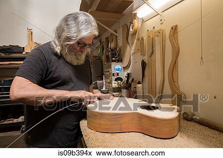 Guitar maker in workshop manufacturing guitar View Large Photo Image Stock Photo - Guitar maker in workshop manufacturing guitar. Fotosearch