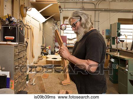 Guitar maker in workshop manufacturing guitar View Large Photo Image Stock Photograph - Guitar maker in workshop manufacturing guitar. Fotosearch