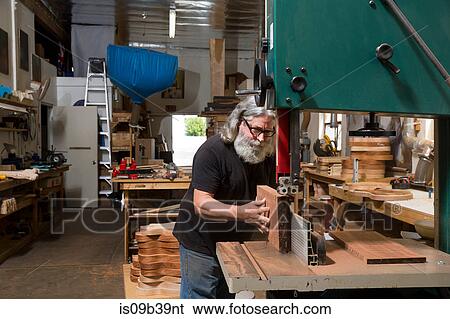 Stock Photograph - Guitar maker in workshop manufacturing guitar. Fotosearch