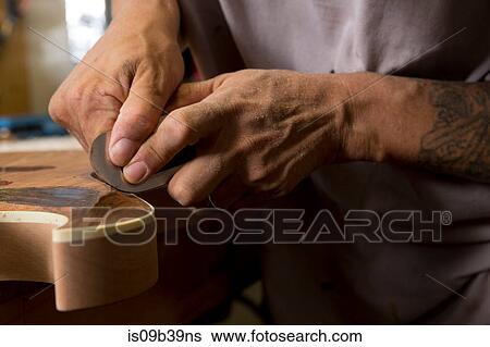 Guitar maker in workshop sanding guitar View Large Photo Image Stock Photograph - Guitar maker in workshop sanding guitar. Fotosearch