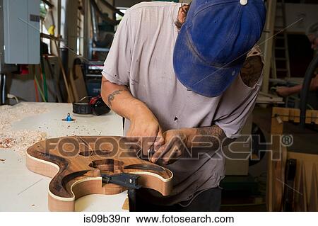 Guitar maker in workshop sanding guitar View Large Photo Image Stock Photography - Guitar maker in workshop sanding guitar. Fotosearch