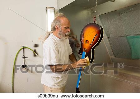 Guitar maker in workshop using cloth to varnish guitar View Large Photo Image Stock Photograph - Guitar maker in workshop using cloth to varnish guitar. Fotosearch