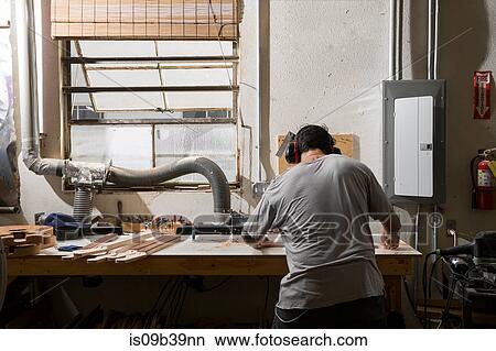 Guitar maker manufacturing guitar in workshop View Large Photo Image Picture - Guitar maker manufacturing guitar in workshop. Fotosearch