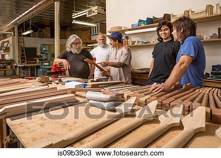 Guitar makers in workshop quality checking guitar necks View Large Photo Image Stock Image - Guitar makers in workshop quality checking guitar necks. Fotosearch