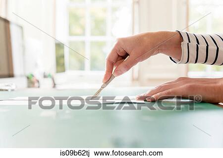 Hand of female designer cutting paper with scalpel in creative studio View Large Photo Image Stock Image - Hand of female designer cutting paper with scalpel in creative studio. Fotosearch
