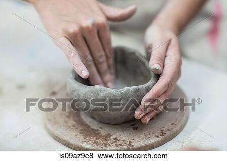 Stock Photo - Hands of female potter shaping clay pot in workshop. Fotosearch