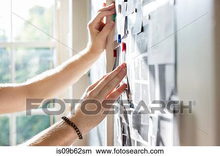 Hands of male designer pinning mood board ideas to wall in creative studio View Large Photo Image Picture - Hands of male designer pinning mood board ideas to wall in creative studio. Fotosearch