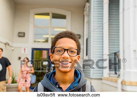 Happy boy standing in front of school View Large Photo Image Stock Photograph - Happy boy standing in front of school. Fotosearch