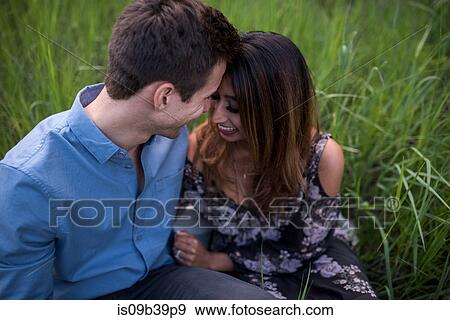 Happy couple on grass field View Large Photo Image Stock Photo - Happy couple on grass field. Fotosearch