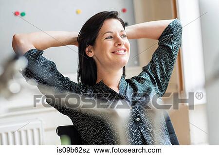 Happy female designer with hands behind her head in creative studio View Large Photo Image Stock Photo - Happy female designer with hands behind her head in creative studio. Fotosearch