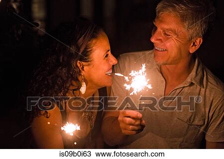 Happy romantic mature couple holding sparklers at night View Large Photo Image Stock Image - Happy romantic mature couple holding sparklers at night. Fotosearch