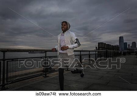 Happy young male runner running on riverside at dawn View Large Photo Image Stock Photograph - Happy young male runner running on riverside at dawn. Fotosearch