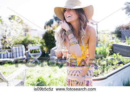 Happy young woman in boho style leaning forward in garden View Large Photo Image Stock Photo - Happy young woman in boho style leaning forward in garden. Fotosearch