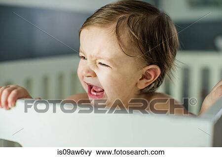 Head and shoulders of baby boy crying in crib View Large Photo Image Stock Photo - Head and shoulders of baby boy crying in crib. Fotosearch