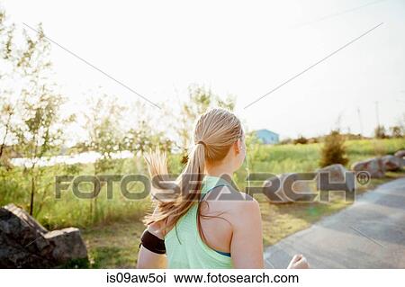 Head and shoulders of woman wearing activity tracker jogging on path View Large Photo Image Stock Image - Head and shoulders of woman wearing activity tracker jogging on path. Fotosearch