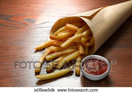 High angle view of chips in paper cone with bowl of tomato ketchup View Large Photo Image Stock Image - High angle view of chips in paper cone with bowl of tomato ketchup. Fotosearch