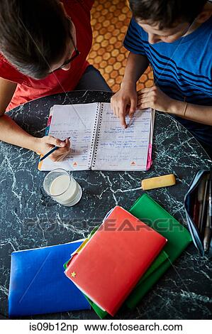 High angle view of mother and son at dining table doing homework View Large Photo Image Stock Photography - High angle view of mother and son at dining table doing homework. Fotosearch