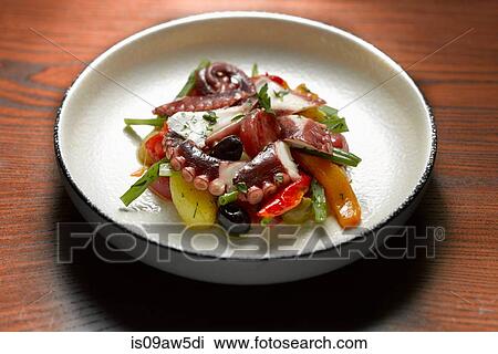 Stock Image - High angle view of octopus seafood salad in shallow bowl. Fotosearch