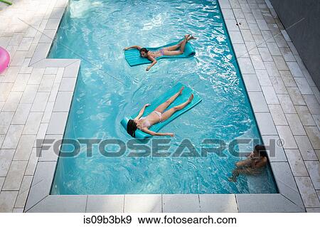 High angle view of two women sunbathing on inflatables in swimming pool, Santa Rosa Beach, Florida, USA View Large Photo Image Stock Photo - High angle view of two women sunbathing on inflatables in swimming pool, Santa Rosa Beach, Florida, USA. Fotosearch