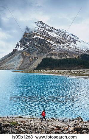 Stock Photo - Hiker hiking along Bow Lake, Banff, Alberta, Canada. Fotosearch