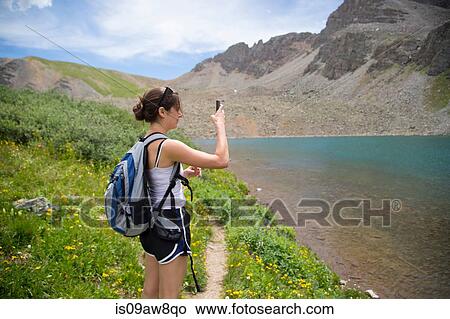 Hiker taking photograph of view, Cathedral Lake, Aspen, Colorado View Large Photo Image Picture - Hiker taking photograph of view, Cathedral Lake, Aspen, Colorado. Fotosearch