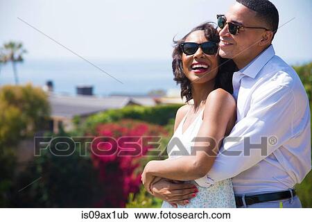 Stock Image - Honeymoon couple hugging near ocean. Fotosearch