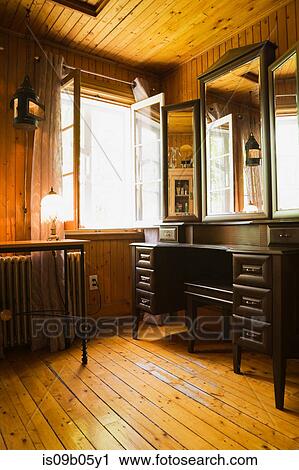 Stock Image - Illuminated powder room with dressing table in 1920s cottage style old home, Quebec, Canada. Fotosearch
