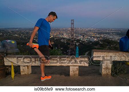 Stock Photo - Jogger stretching leg, Runyon Canyon, Los Angeles, California, USA. Fotosearch