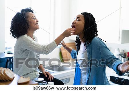 Lesbian couple fooling around in kitchen View Large Photo Image Stock Photo - Lesbian couple fooling around in kitchen. Fotosearch