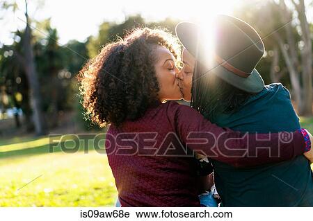 Stock Image - Lesbian couple kissing in the park. Fotosearch