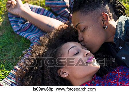 Lesbian couple lying together in park, woman kissing partner on head View Large Photo Image Stock Photography - Lesbian couple lying together in park, woman kissing partner on head. Fotosearch