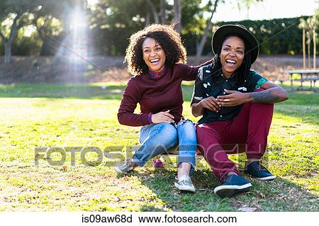 Lesbian couple relaxing in park, sitting together, laughing View Large Photo Image Stock Image - Lesbian couple relaxing in park, sitting together, laughing. Fotosearch