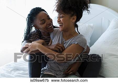 Lesbian couple relaxing on bed, hugging, laughing View Large Photo Image Stock Image - Lesbian couple relaxing on bed, hugging, laughing. Fotosearch