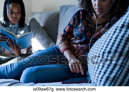 Lesbian couple relaxing sofa, reading book and using digital tablet View Large Photo Image Stock Image - Lesbian couple relaxing sofa, reading book and using digital tablet. Fotosearch