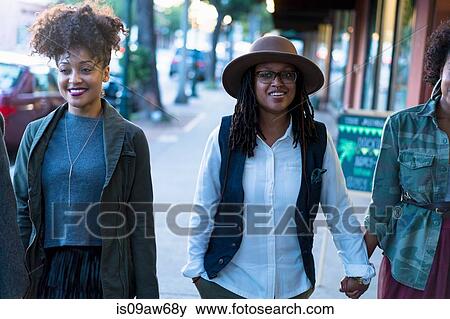 Lesbian couple walking along street, holding hands View Large Photo Image Stock Photo - Lesbian couple walking along street, holding hands. Fotosearch