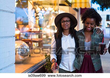 Lesbian couple walking along street, arms around each other, carrying takeaway drinks View Large Photo Image Stock Photo - Lesbian couple walking along street, arms around each other, carrying takeaway drinks. Fotosearch