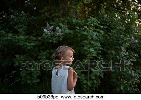 Stock Photography - Little girl, green bushes in background. Fotosearch