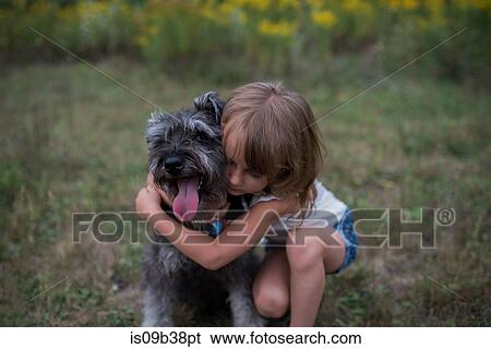 Little girl hugging pet dog on grass field View Large Photo Image Stock Photograph - Little girl hugging pet dog on grass field. Fotosearch