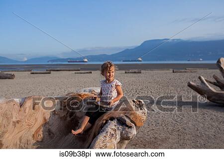 Little girl playing on wood sculpture on beach, Vancouver, British Columbia, Canada View Large Photo Image Stock Image - Little girl playing on wood sculpture on beach, Vancouver, British Columbia, Canada. Fotosearch